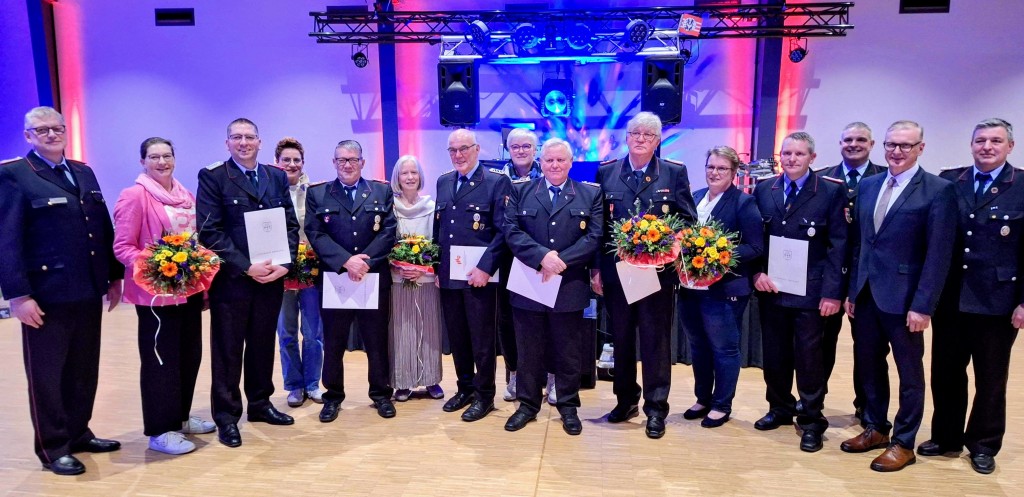 Bild1: Gruppenfoto der geehrten Feuerwehrleute inkl. Partnerinnen, Feuerwehrführung und Samtgemeindebürgermeister